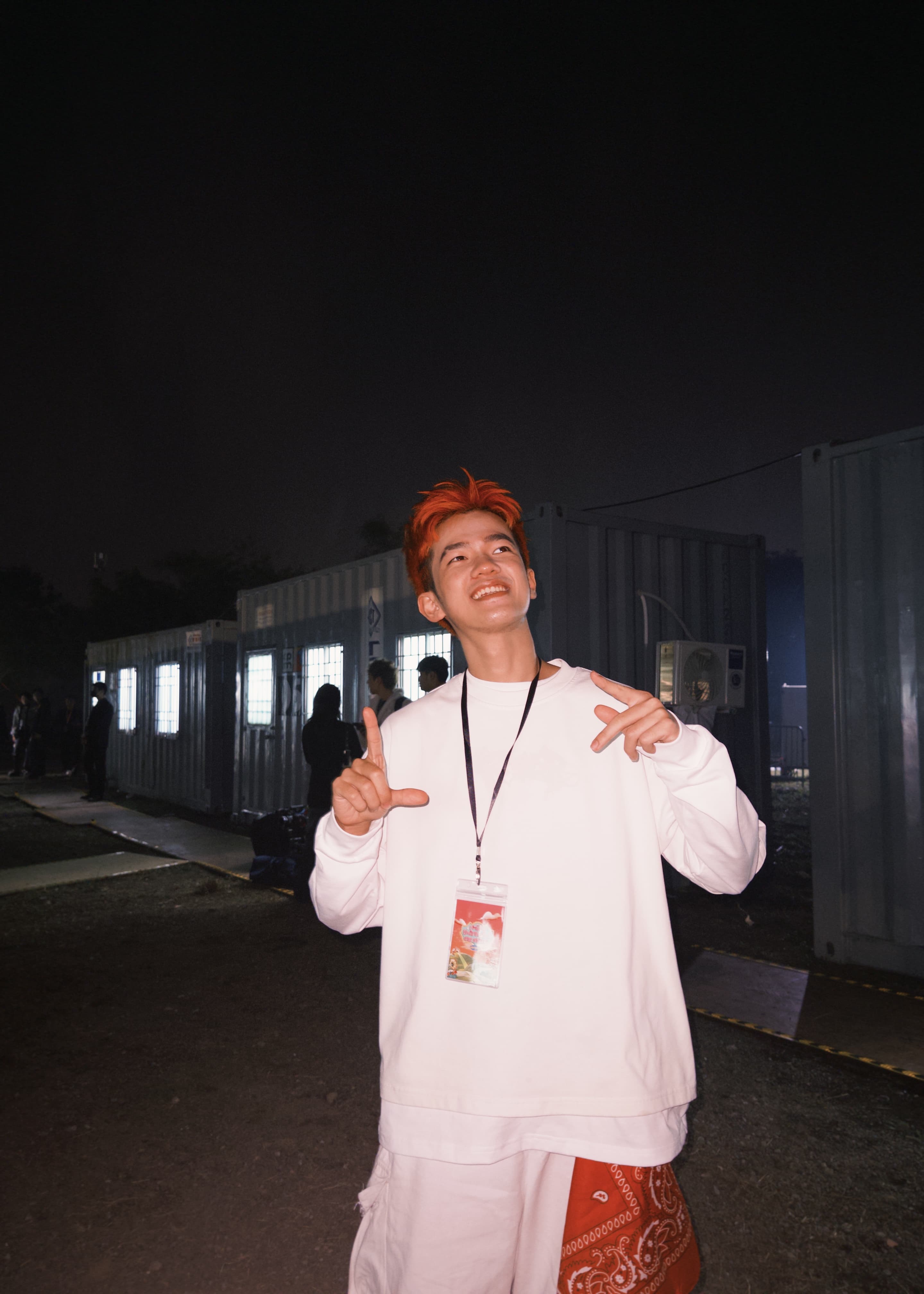 Ddoofi posing in a white outfit at night